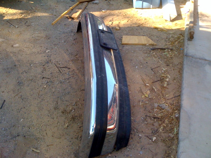Chrome bumper with license plate bracket lying on the ground
