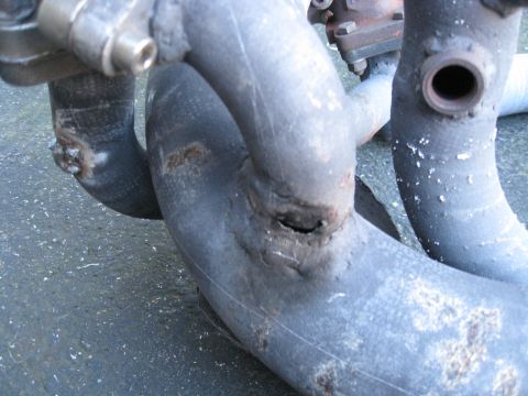 1994 Ford Probe - This exhaust manifold shows significant damage, including a hole that indicates a need for repair or replacement.