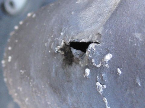 1994 Ford Probe - A close-up view of a damaged metal component, showing a hole and flaking material. The Supermotors.net logo is visible at the bottom right.