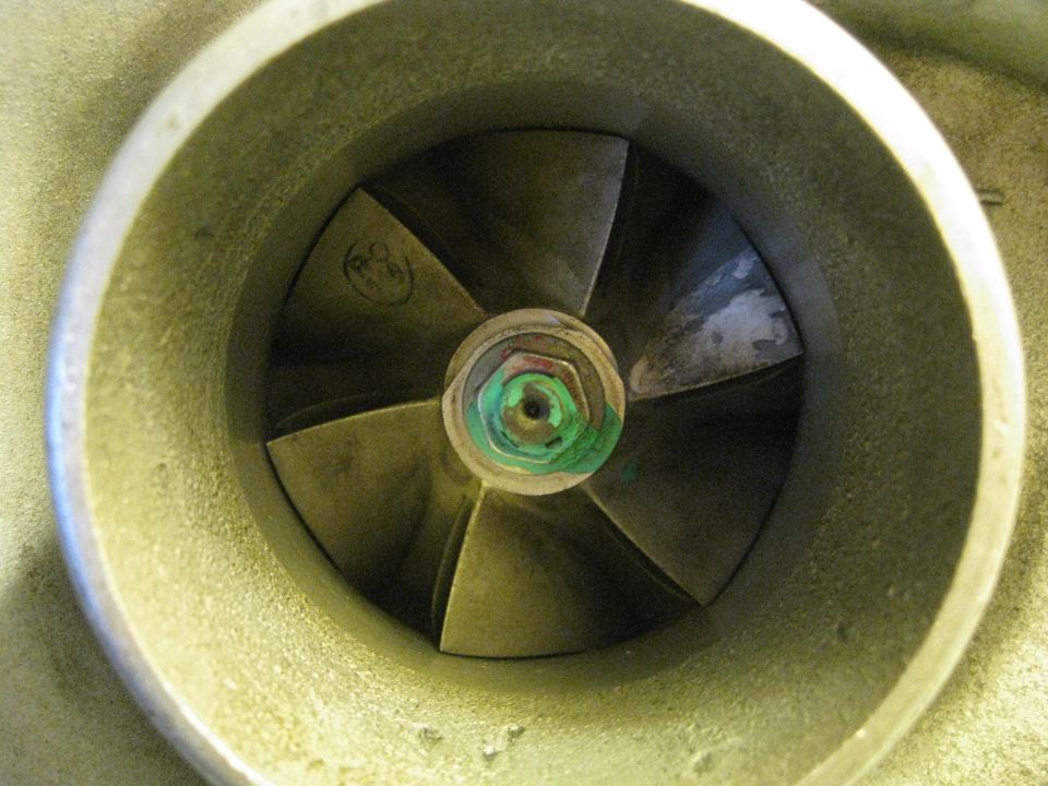 Turbocharger compressor wheel with visible markings and a green-tinted nut