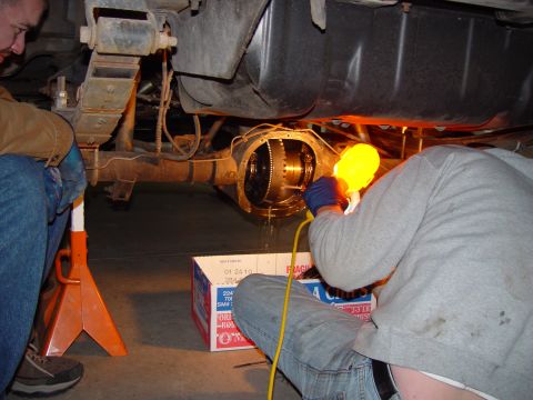 1993 Ford Bronco - Mechanics work on the rear axle differential of a 1993 Ford Bronco, likely during a rebuild.