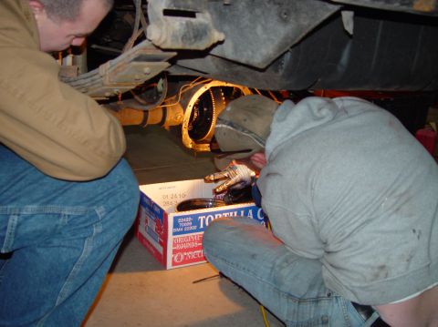 1993 Ford Bronco - Mechanics drain fluid from a vehicle's rear axle into a "Tortilla Chips" box during a repair.