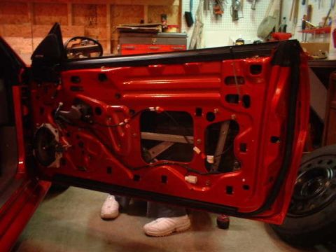 1994 Ford Mustang - The interior of a car door is exposed, revealing its inner workings and a speaker.