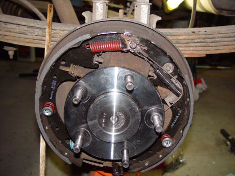 1993 Ford Bronco - Close-up of a vehicle's rear axle brake assembly, showing new brake shoes and springs.