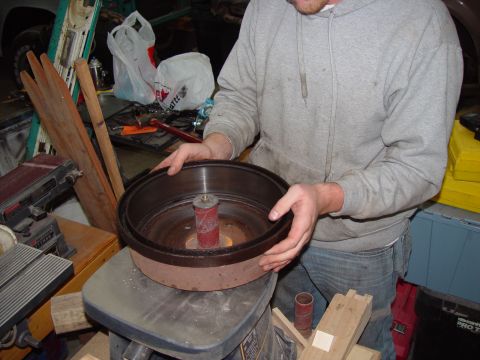 1993 Ford Bronco - A person holds a brake drum, possibly for servicing, with a sanding drum visible below.
