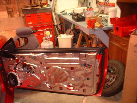 1994 Ford Mustang - The interior of a car door is visible, showing insulation and speaker components.