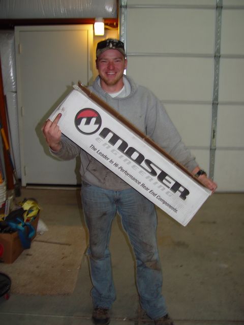 1993 Ford Bronco - Man proudly displays a box of Moser Engineering rear end components, likely for a vehicle rebuild.