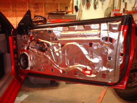 1994 Ford Mustang - The interior of a red 1994 Ford Mustang door is shown with sound deadening material applied.