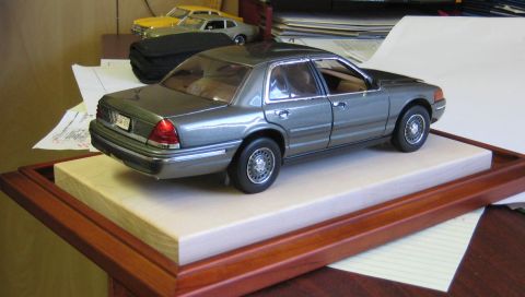 1999 Ford Crown Victoria - Model car display features a Ford Crown Victoria and two other vehicles in the background.