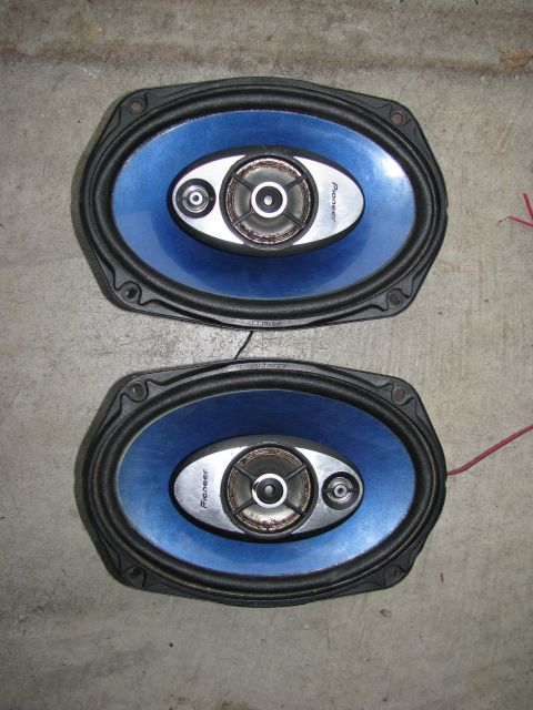 2004 Ford Crown Victoria - Two Pioneer car speakers are shown on a concrete floor, with visible wiring.