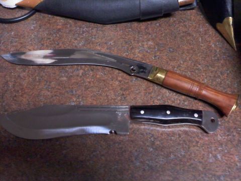 1977 Ford F-100 - Two knives are displayed on a speckled surface. One knife has a curved blade and a wooden handle, while the other has a straight blade and…