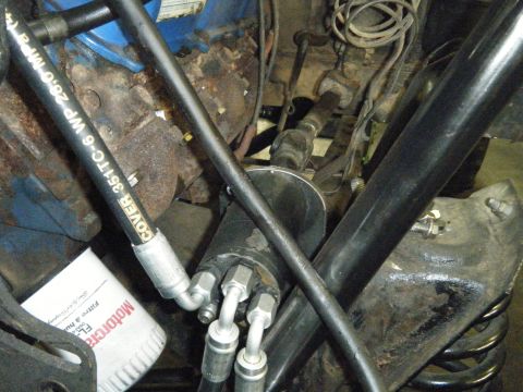 1978 Ford Bronco - Close-up view of engine bay components, including hydraulic lines and an oil filter.
