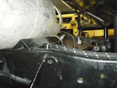 1978 Ford Bronco - Close-up view of the undercarriage components of a vehicle, including a large tank and drive shaft.