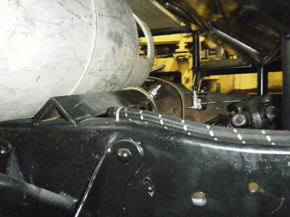 Underside of a vehicle with a large tank and drive shaft visible