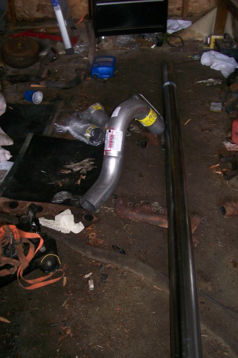 1992 Ford C-350 (Centurion Conversions) - Garage scene with exhaust pipe components and various tools scattered around.