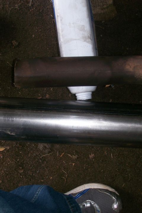 1992 Ford C-350 (Centurion Conversions) - Sealant is applied to an exhaust pipe, likely for repair or installation.