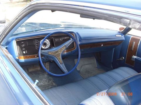1991 Ford Crown Victoria - Interior view of a blue car, showing the dashboard, steering wheel, and bench seat.