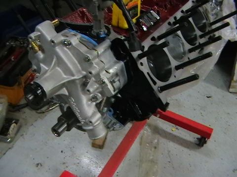 1996 Ford Bronco - Engine block with water pump assembly mounted on a red engine stand.