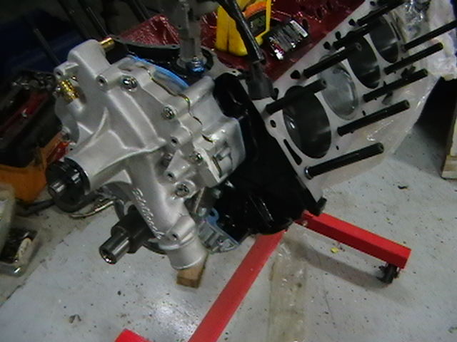 Engine block on red stand with silver housing in a workshop
