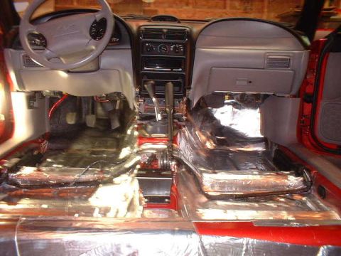 1994 Ford Mustang - Sound deadening installation in a 1994 Ford Mustang interior, with seats removed for access.