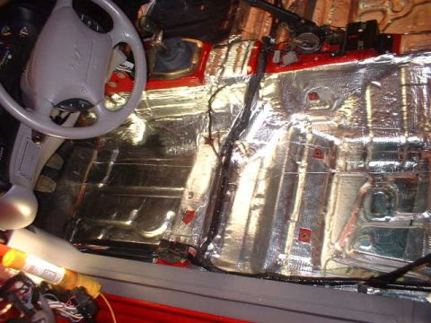 1994 Ford Mustang - Sound deadening material is being applied to the floor of a vehicle's interior.