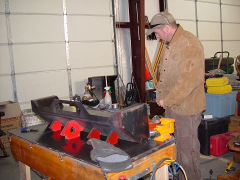 1993 Ford Bronco - Custom bumper fabrication in progress, with a man observing the work on a workbench.