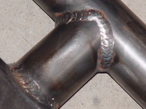 1993 Ford Bronco - Welded metal tubing shows distinct weld beads and heat discoloration on a concrete background.