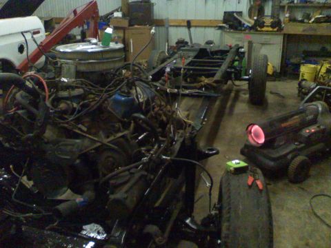 1979 Ford F-250 - The front end of a 1979 Ford F-250 is disassembled in a workshop, revealing the engine and chassis.