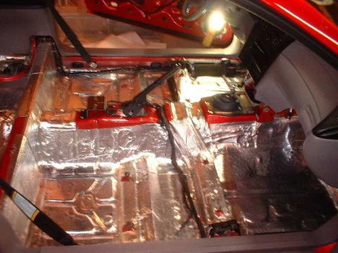 1994 Ford Mustang - Sound deadening material covers the floor and transmission tunnel of a 1994 Ford Mustang interior.