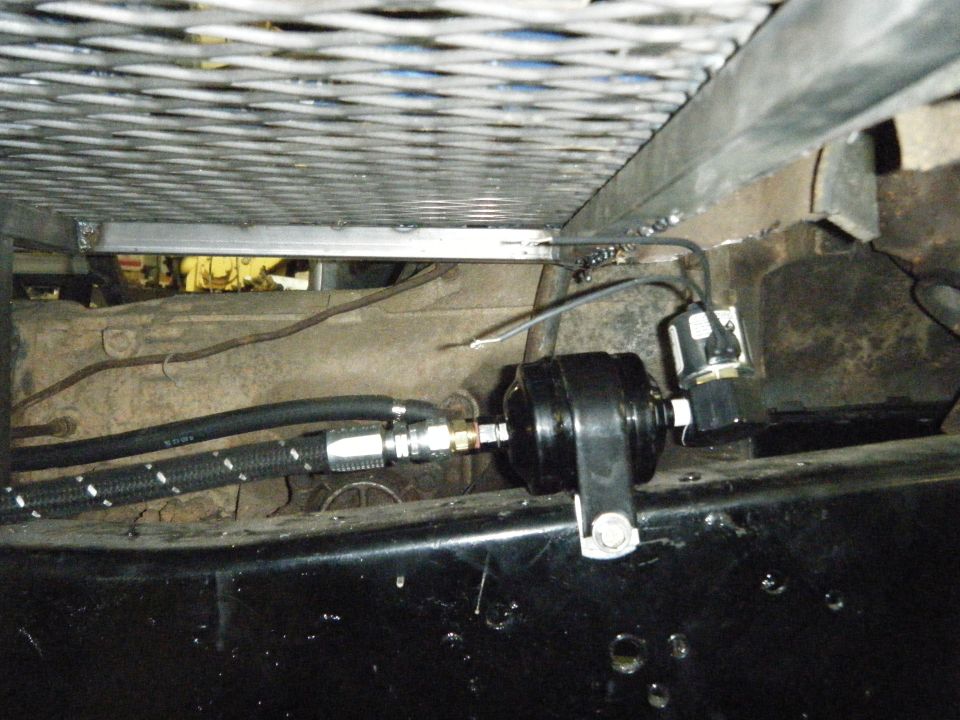 Fuel filter and braided lines attached to a metal bracket under a vehicle chassis