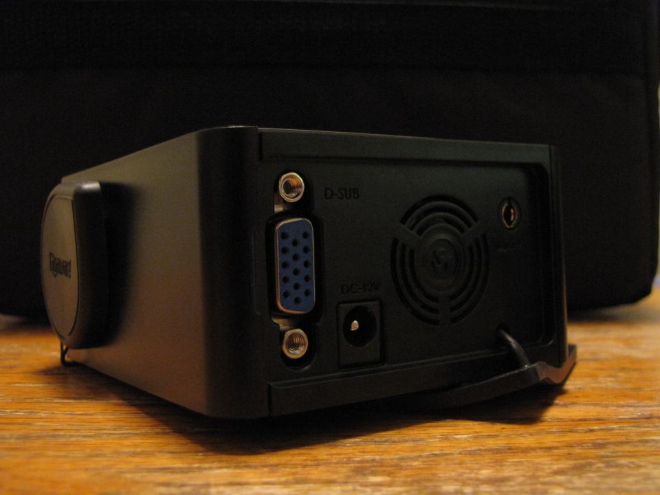 Rear of a black projector showing D-SUB and DC-12V ports, plus a fan vent