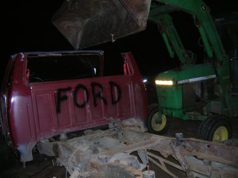 1996 Ford Bronco - A Ford truck cab and chassis is being worked on next to a John Deere tractor.