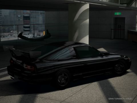 2000 Mercury Grand Marquis - A black sports coupe with a large rear spoiler is parked indoors near a building.
