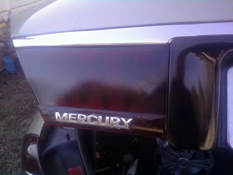 2000 Mercury Grand Marquis - Close-up of the Mercury emblem on the rear of a vehicle.