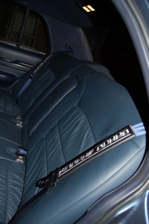1985 Mercury Grand Marquis - Interior view of a car's rear seat, focusing on the blue upholstery and seatbelt.