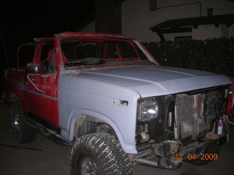 1985 Ford Bronco - Ford Bronco in progress, showing primer on the fender and red bodywork.
