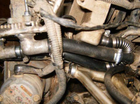 2000 Ford E350 - Engine bay detail showing various hoses and mechanical parts, with a visible warning label.