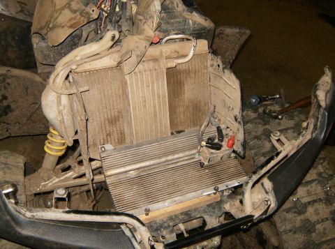 2000 Ford E350 - The radiator and cooling system of a dirty off-road vehicle are exposed, with tools visible in the background.