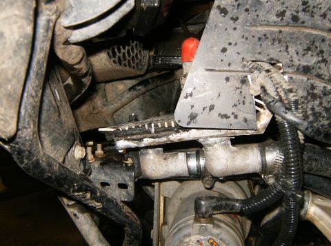 2000 Ford E350 - Close-up view of engine components including hoses, pipes, and a red cap, with visible text from SuperMotors.net.