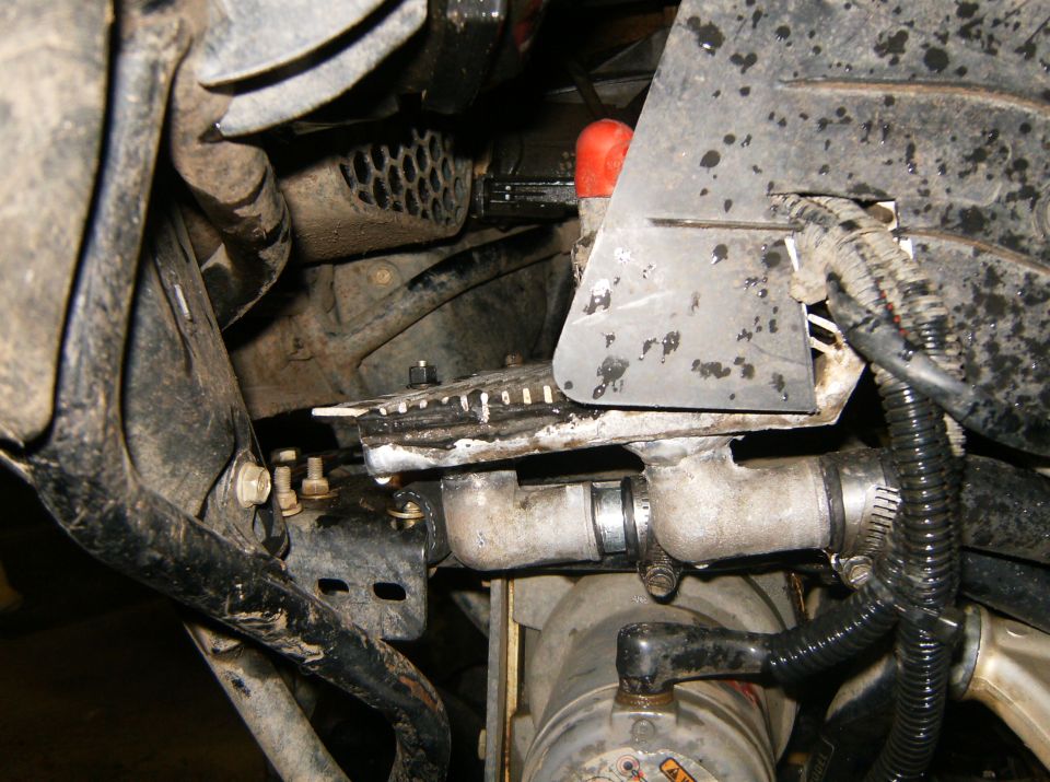 Engine hoses and metal pipes with clamps and a red cap