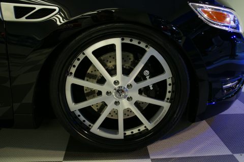 1993 Ford Taurus - Custom wheels and brakes are visible on the front of a black car.