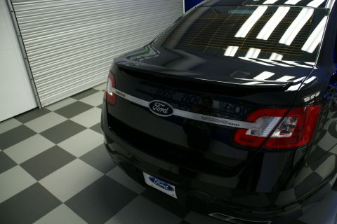 1993 Ford Taurus - Rear view of a black Ford Taurus SHO with a spoiler and chrome accent strip.