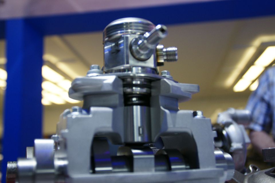 Cutaway view of an engine piston assembly showing the piston, connecting rod, and cylinder