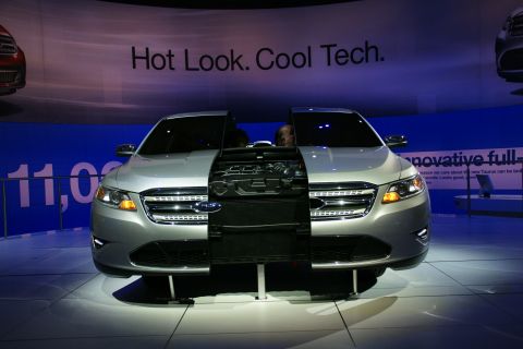 1993 Ford Taurus - A silver Ford Taurus is displayed with its front end cutaway to reveal the engine and cooling system, under a banner reading "Hot Look. Coo…