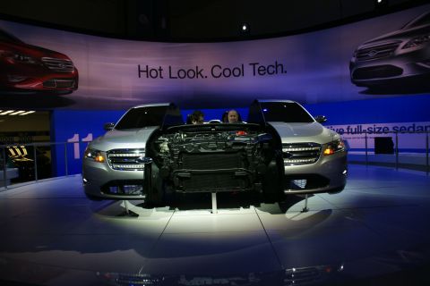 1993 Ford Taurus - Ford Taurus display at an auto show, highlighting its engine and technology.