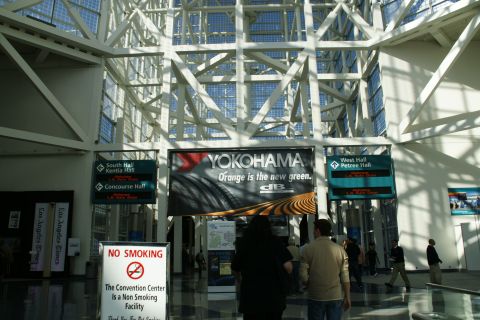 1993 Ford Taurus - Interior view of a convention center, directional signs and a large Yokohama tire advertisement.