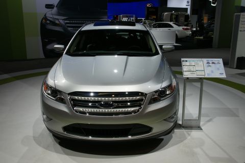 1993 Ford Taurus - This silver sedan features a prominent chrome grille and a sunroof, displayed at an auto show.