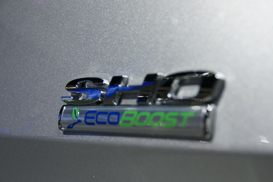 Close-up of an EcoBoost badge with blue and green lettering on a silver car body