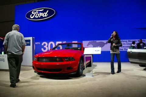 1993 Ford Taurus - Red convertible displayed at the LA Auto Show with Ford branding and promotional signage.