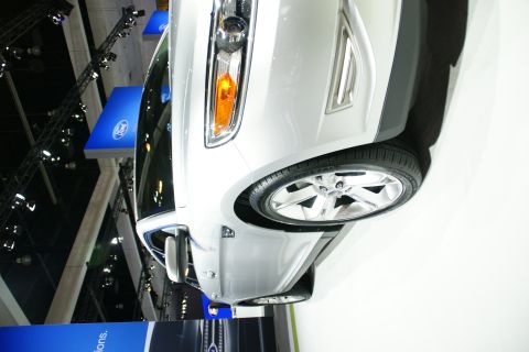 1993 Ford Taurus - Close-up view of the front corner of a silver vehicle at an auto show.